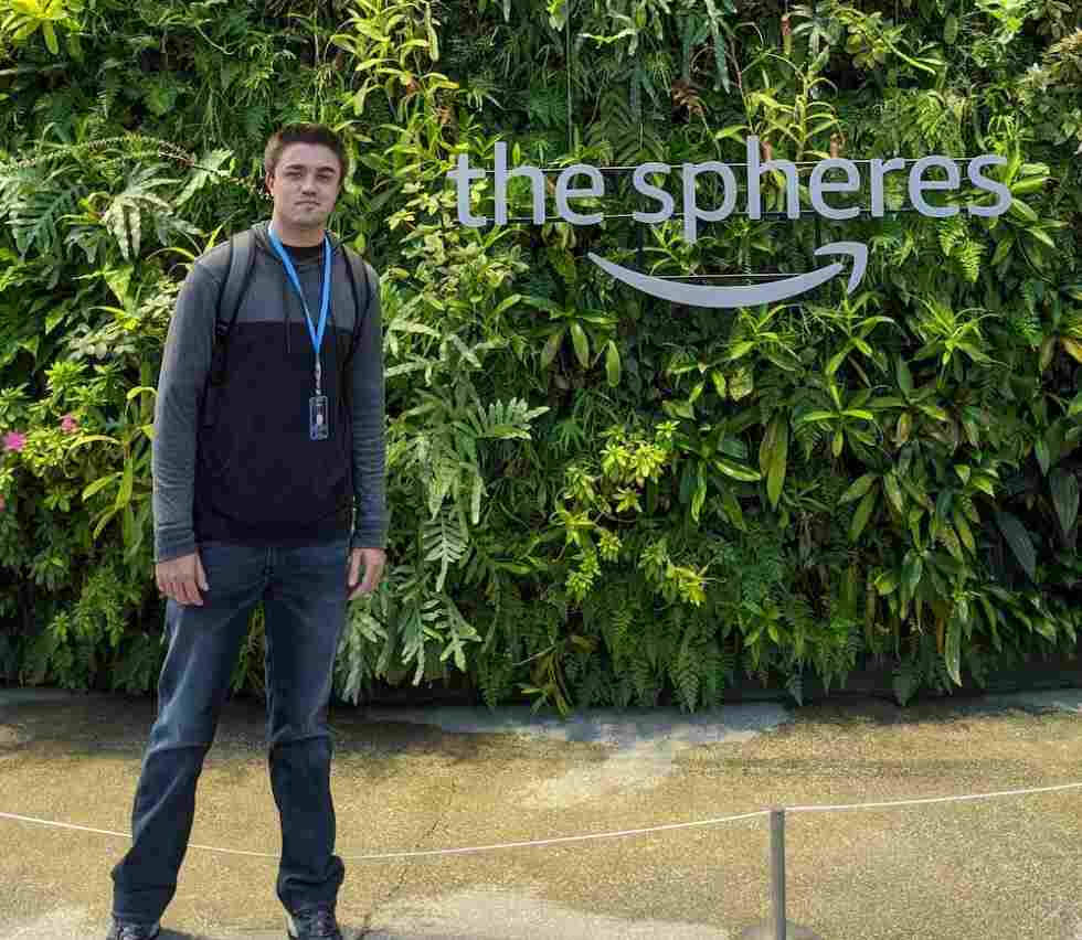 A man standing next to amazon -the spheres